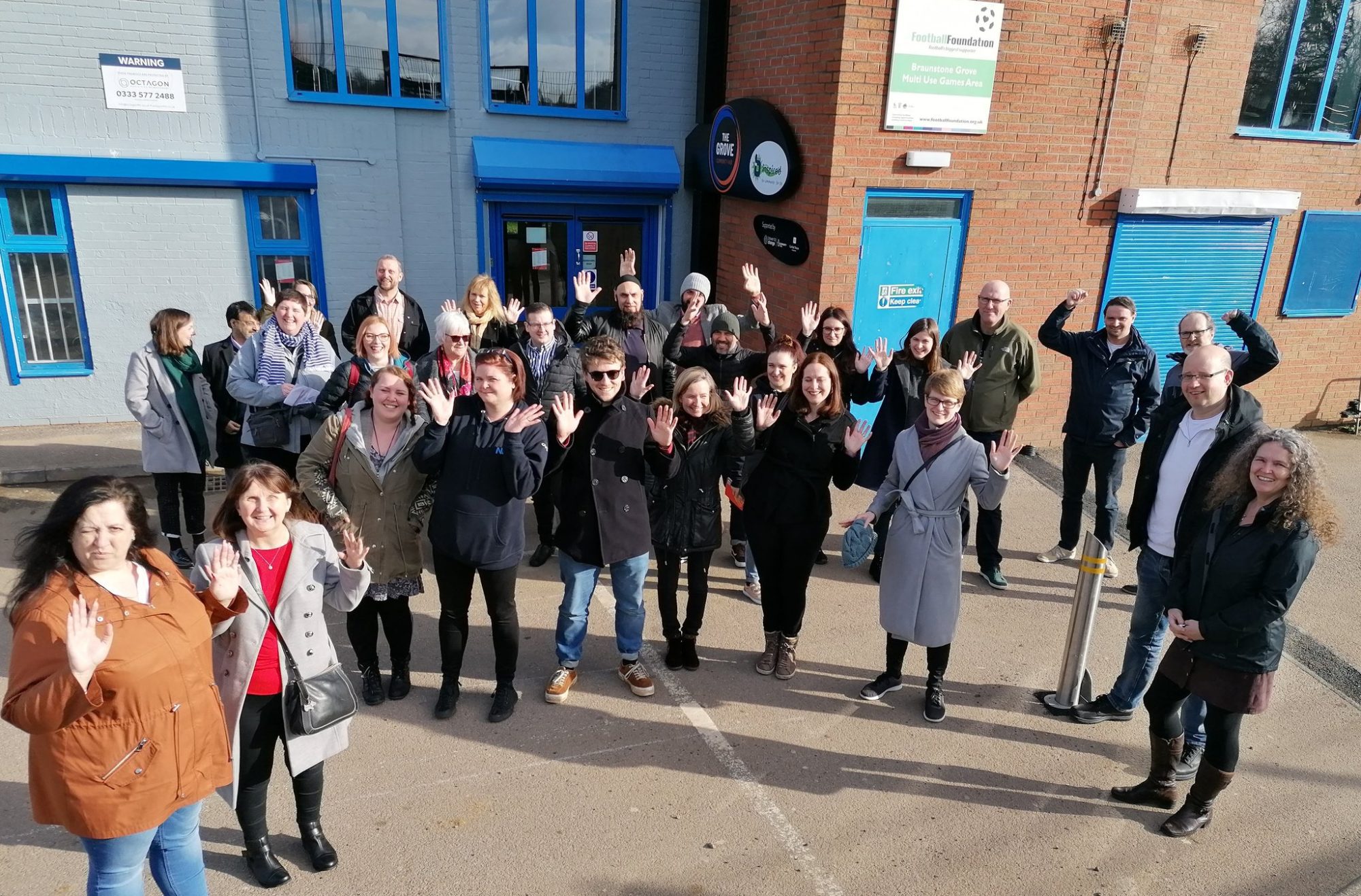 Participants of the Empowering Places Learning Camp in Leicester Participants of the Empowering Places Learning Camp in Leicester raising their hands in front of a building