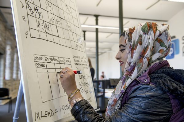 person writing on a whiteboard